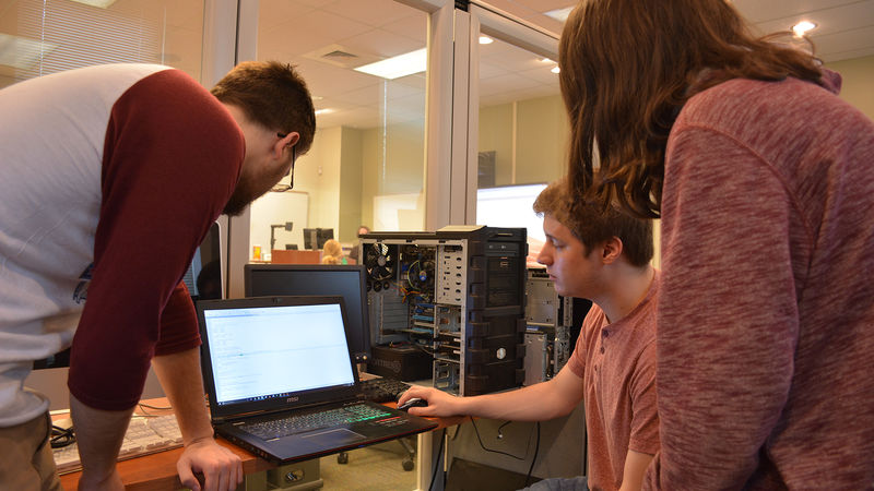 IST students view their mobile game prototype on a computer