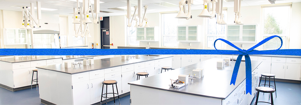 room view of new chemistry lab with a blue ribbon overlaid on top of the photo