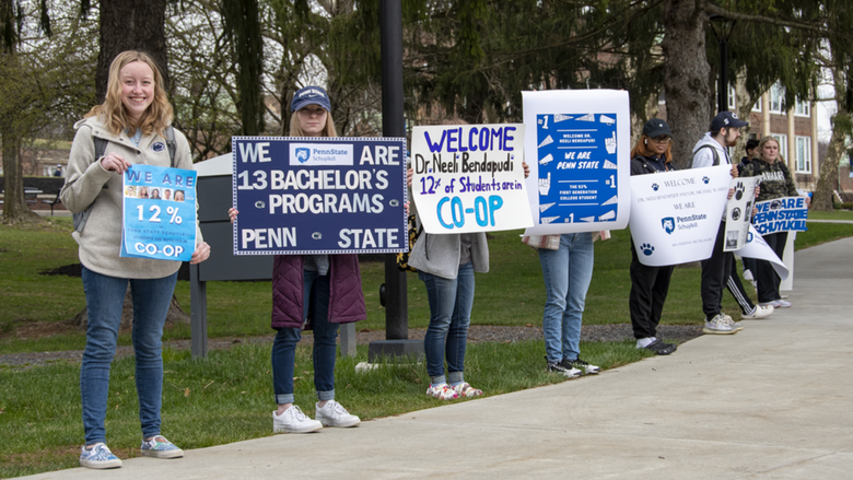 Students standing outdoors holding signs with Penn State Schuylkill facts