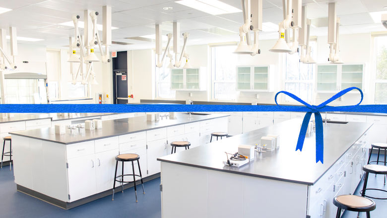 Photo of Penn State Schuylkill's new general chemistry lab, including snorkel ventilation system and lab desks, with a blue ribbon
