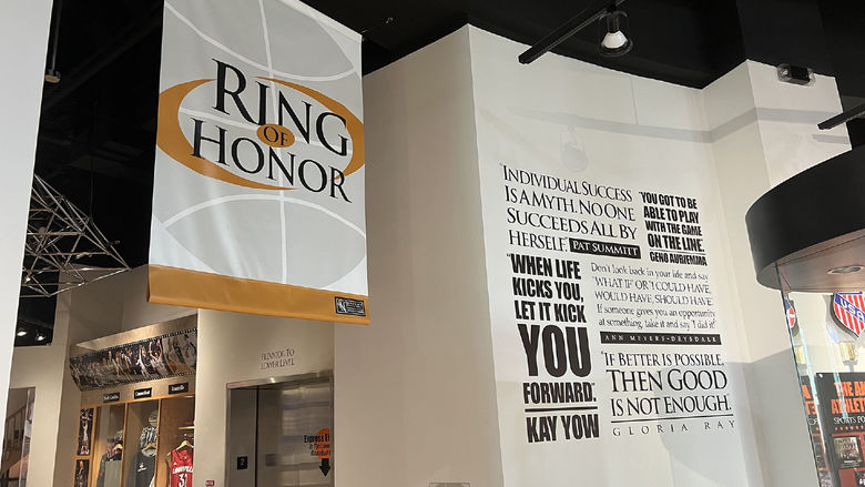 Banner hanging from ceiling that reads "RING OF HONOR" in front of an exhibit that looks like a mock locker room