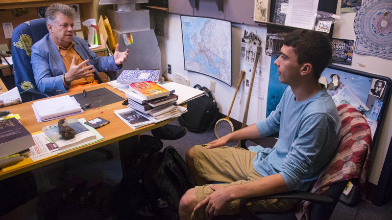 Dr. Cantalupo sits in his eclectic office speaking to a student