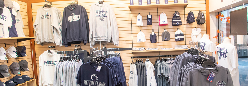Penn State branded hoodies, t-shirts, hats, and gloves hang from the walls of Penn State Schuylkill's bookstore