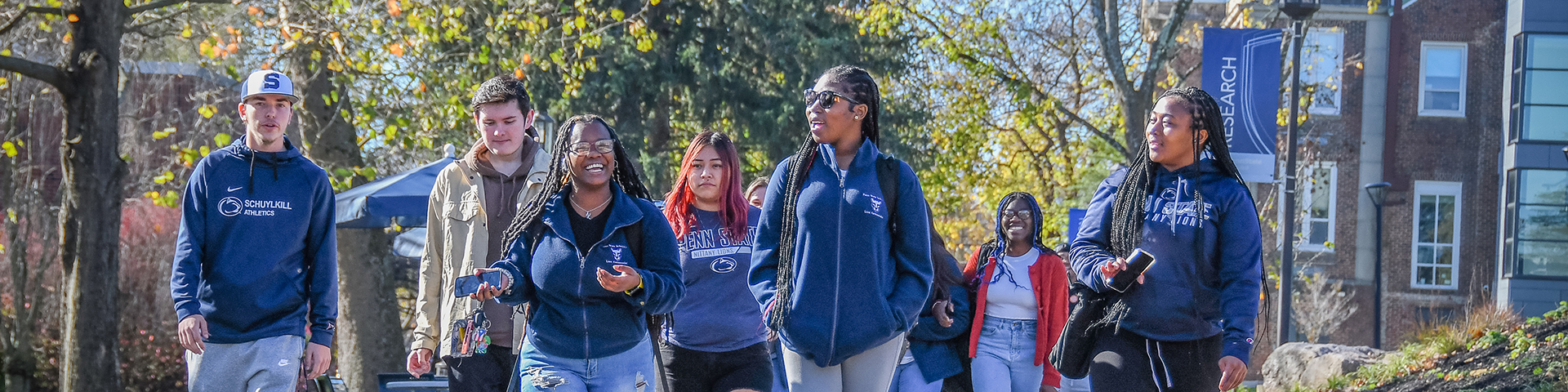 group of students walking on campus mall walk