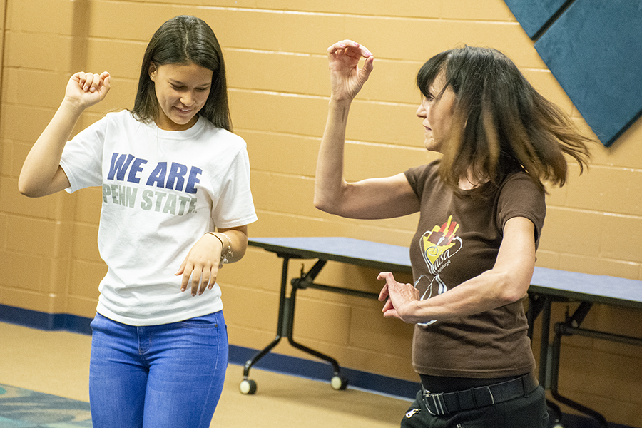 A student learns how to salsa dance from a seasoned teacher.
