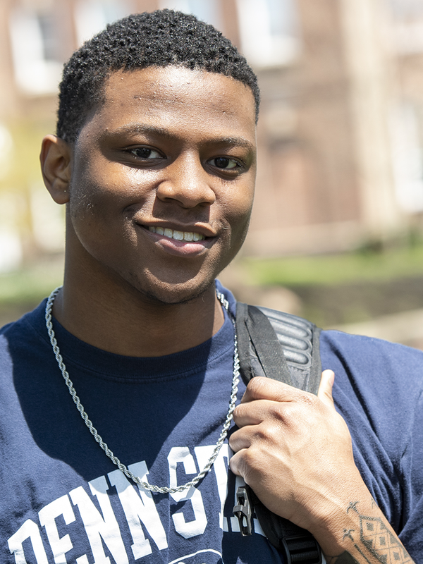 Student in Penn State t-shirt smiling at camera