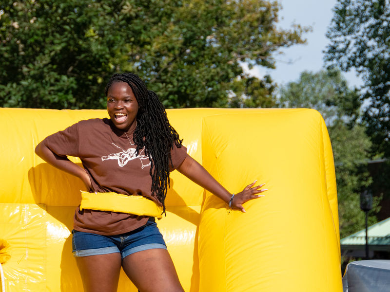 Outdoor shot of a female on a bounce house during Welcome Week