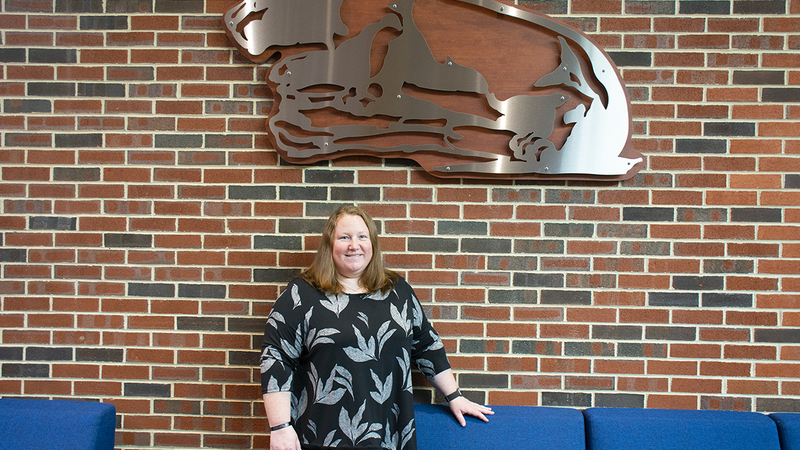 Crystal Shillaci stands under the Nittany Lion in the Student Community Center.