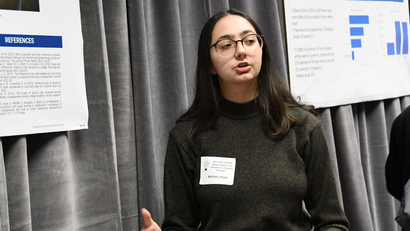 Female student presents research at conference