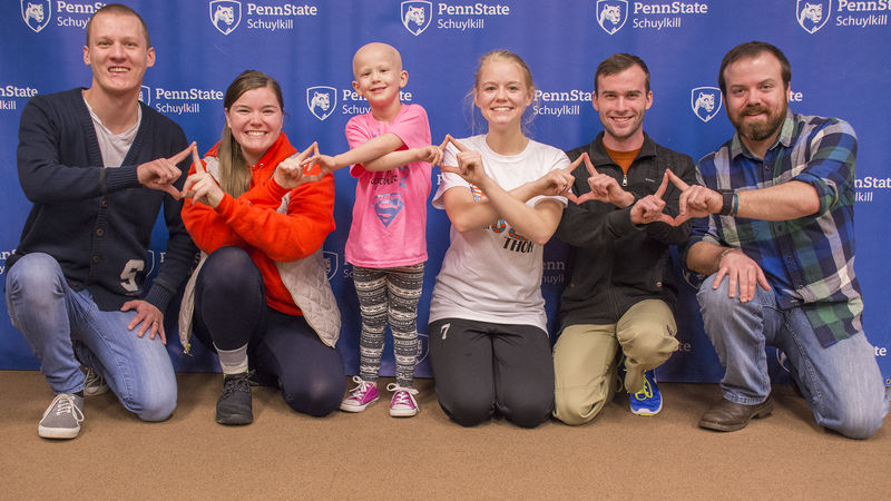 Schuylkill THON dancers pose for a photo with THON child Devin and her father Nick