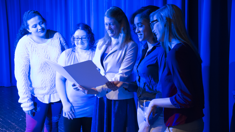 Kyanna, Brenna, Dr. Valerie Schrader, Christina and Baylee examine their submissions.