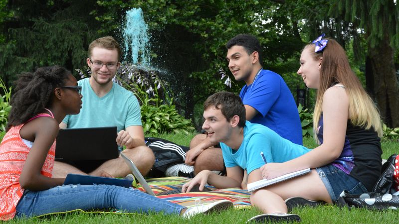 Students conversing around campus fountain