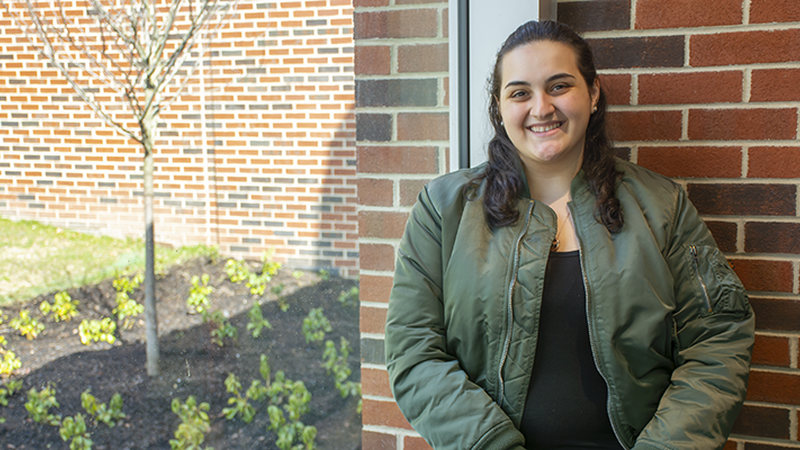 Leila Duka stands next to a window in the Student Community Center.