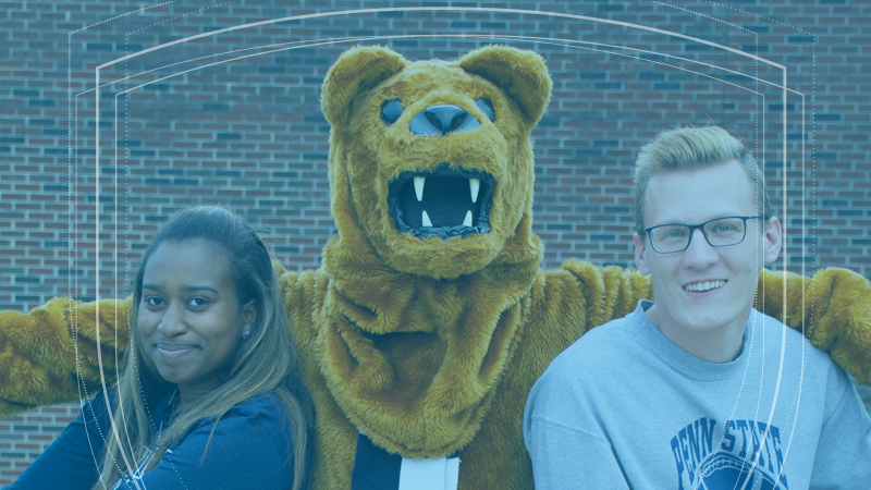 The Nittany Lion mascot wraps its arms around two Penn State students.