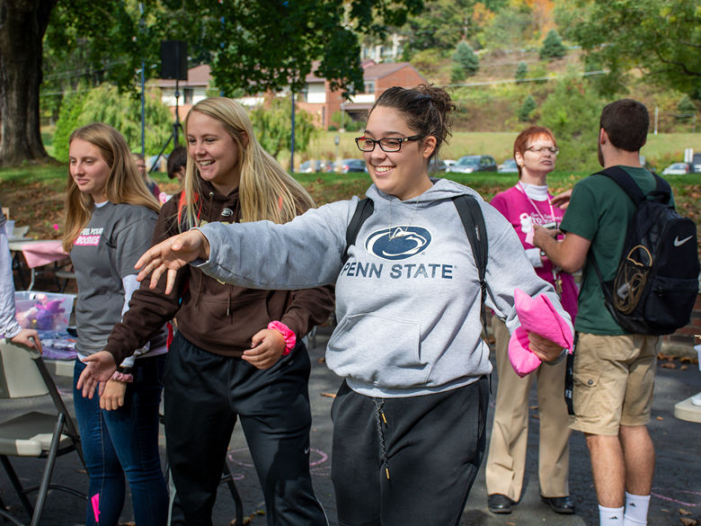 Students wearing Penn State gear playing cornhole