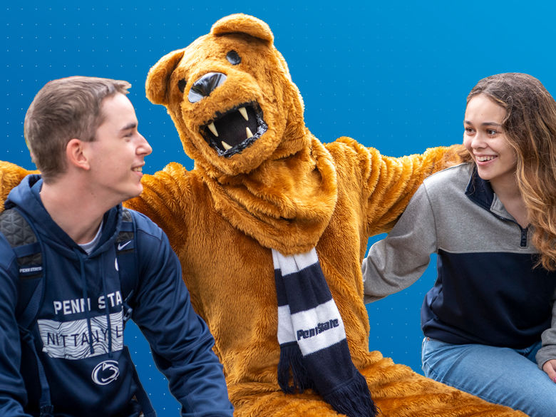 Two students wearing Penn State gear with Penn State Nittany Lion mascot with his arms draped around them.