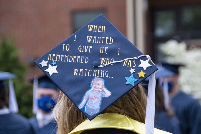 Navy blue mortarboard with text reading "When I wanted to give up, I remembered who was watching" with a photo of a little boy.