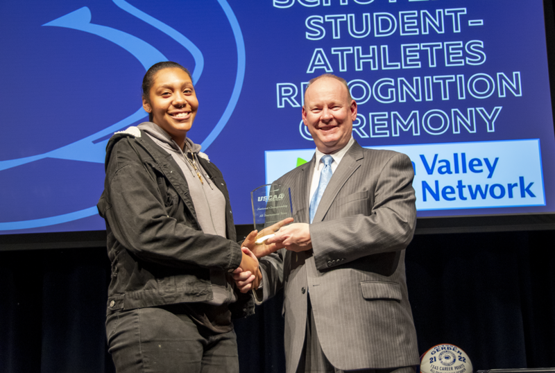 A female student-athlete receives award.