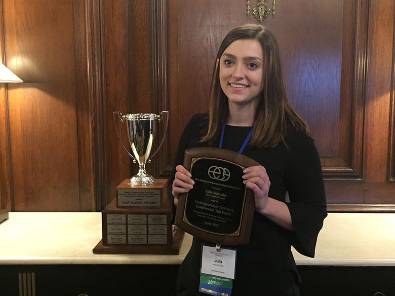 Julia Schuller poses with her plaque after being ranked #1 out of all student submissions at the conference.