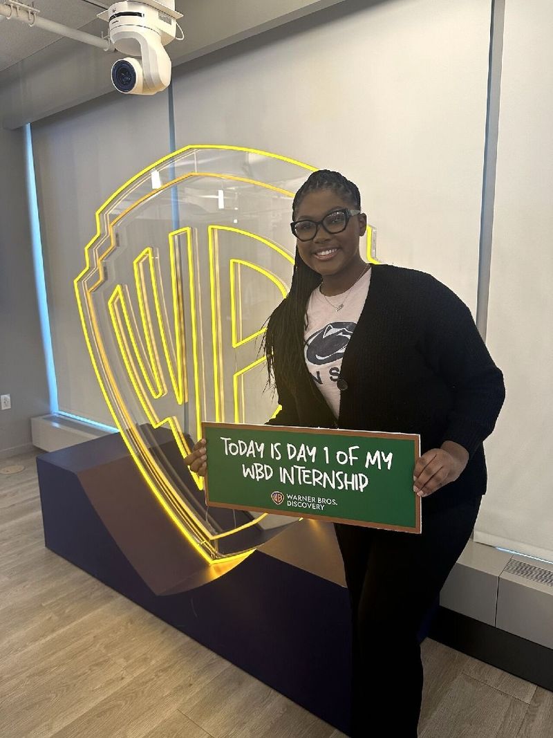 A student holds a sign that reads Today is Day 1 of my WBD internship