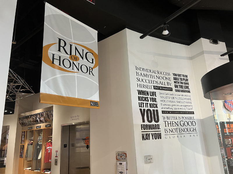 Banner hanging from ceiling that reads "RING OF HONOR" in front of an exhibit that looks like a mock locker room