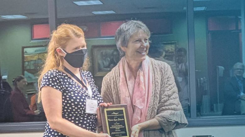 Valerie Schrader accepts a communications award 