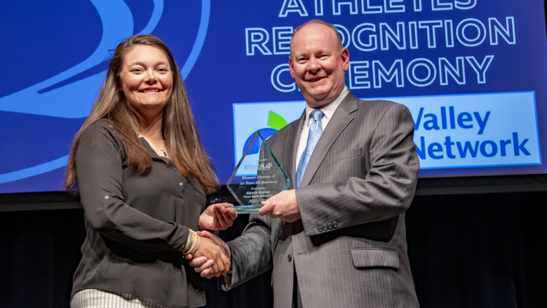 A female student-athlete receives award.