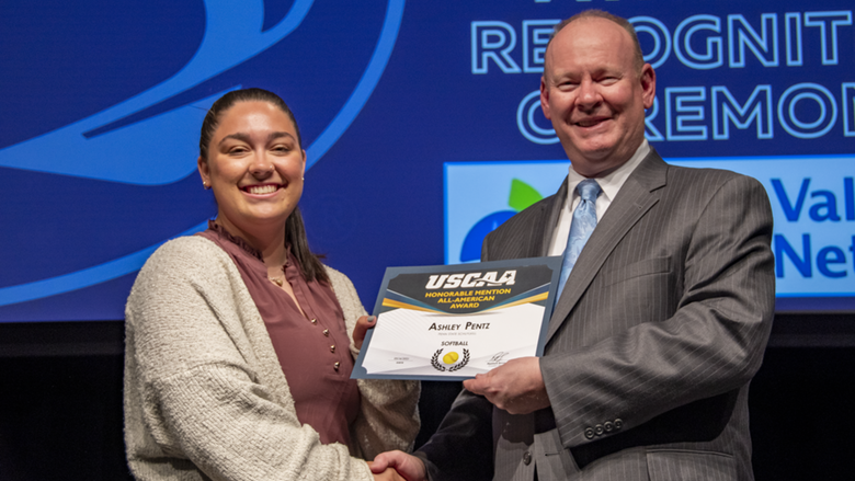 A female student-athlete receives award.