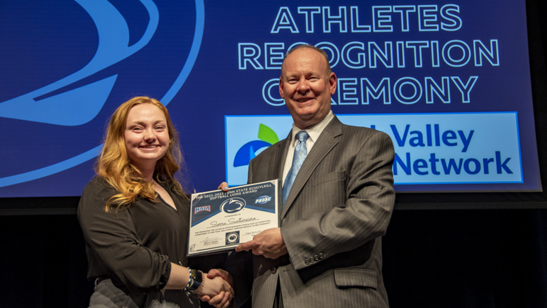 A female student-athlete receives award.