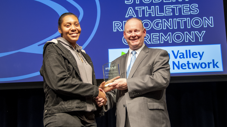 A female student-athlete receives award.