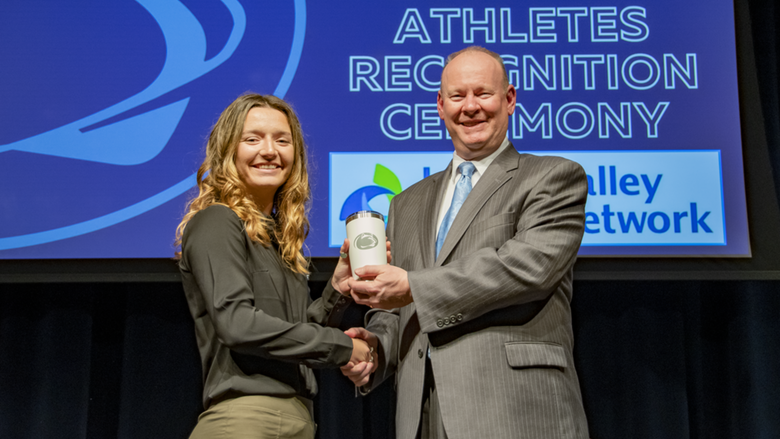 A female student-athlete receives award.
