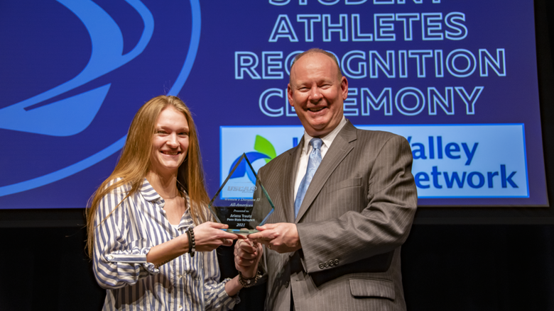 A female student-athlete receives award.