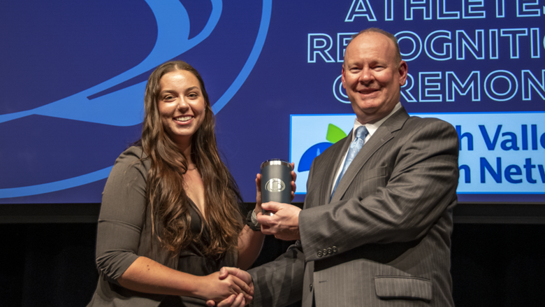 A female student-athlete receives award.