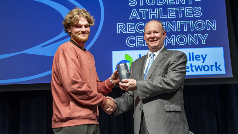 A male student-athlete receives award.