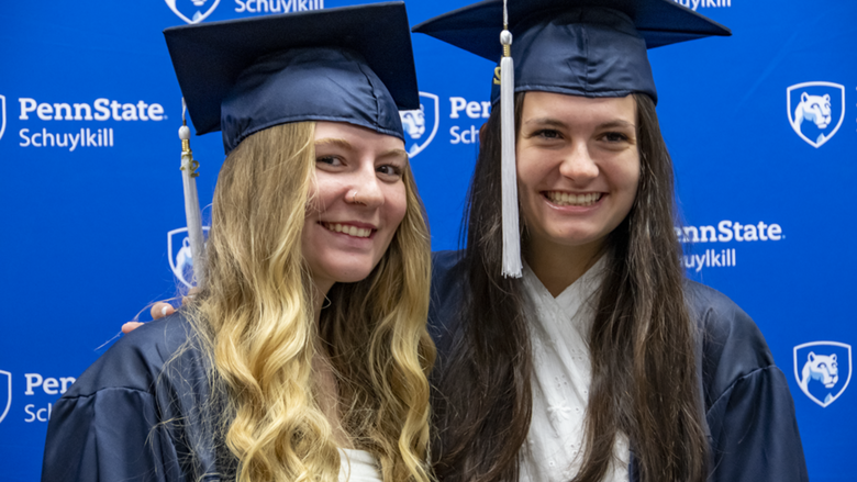 Two female students in graduation attire.