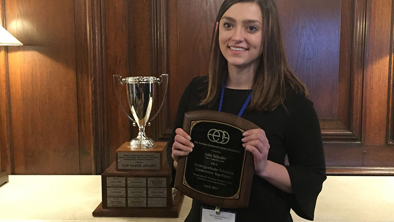 Julia Schuller poses with her plaque after being ranked #1 out of all student submissions at the conference.