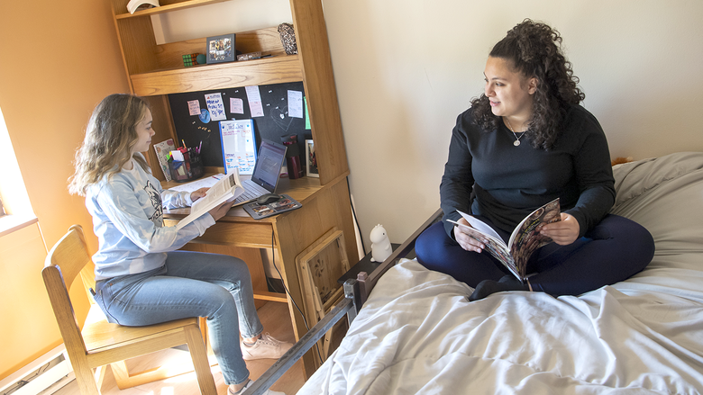 Two students sit together in a dorm room 