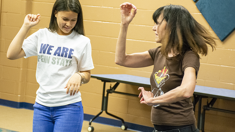 A student learns how to salsa dance from a seasoned teacher.