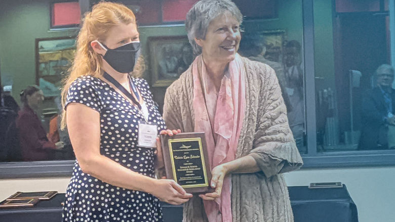 Valerie Schrader accepts a communications award 
