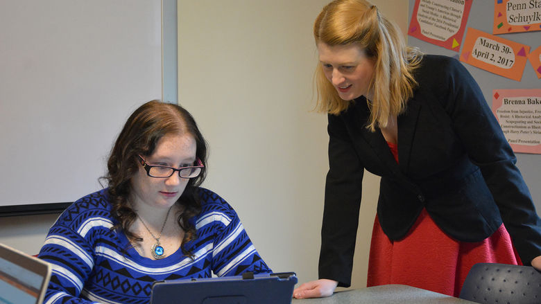 Brenna and Dr. Schrader look over paper