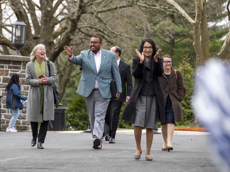 Small group of people walking outdoors toward the camera