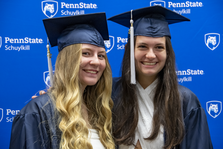 Two female students in graduation attire.