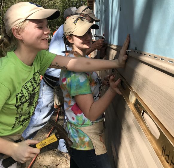 Students install vinyl siding during a Habitat for Humanity build in Florida.