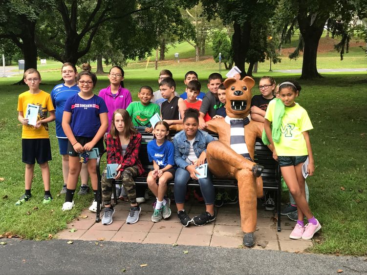 STEM Saturday students perch themselves on Penn State Schuylkill's lion bench