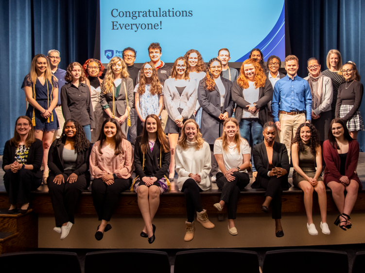 Honors students pose on stage.