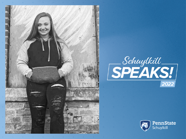 Image of female student  leaning against wall with Schuylkill Speaks! graphics