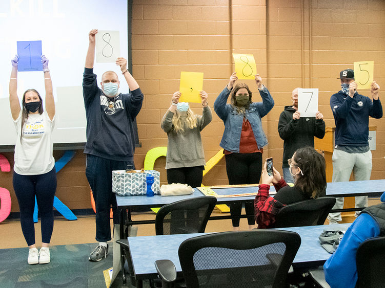 Students in a line holding signs with numbers above their heads